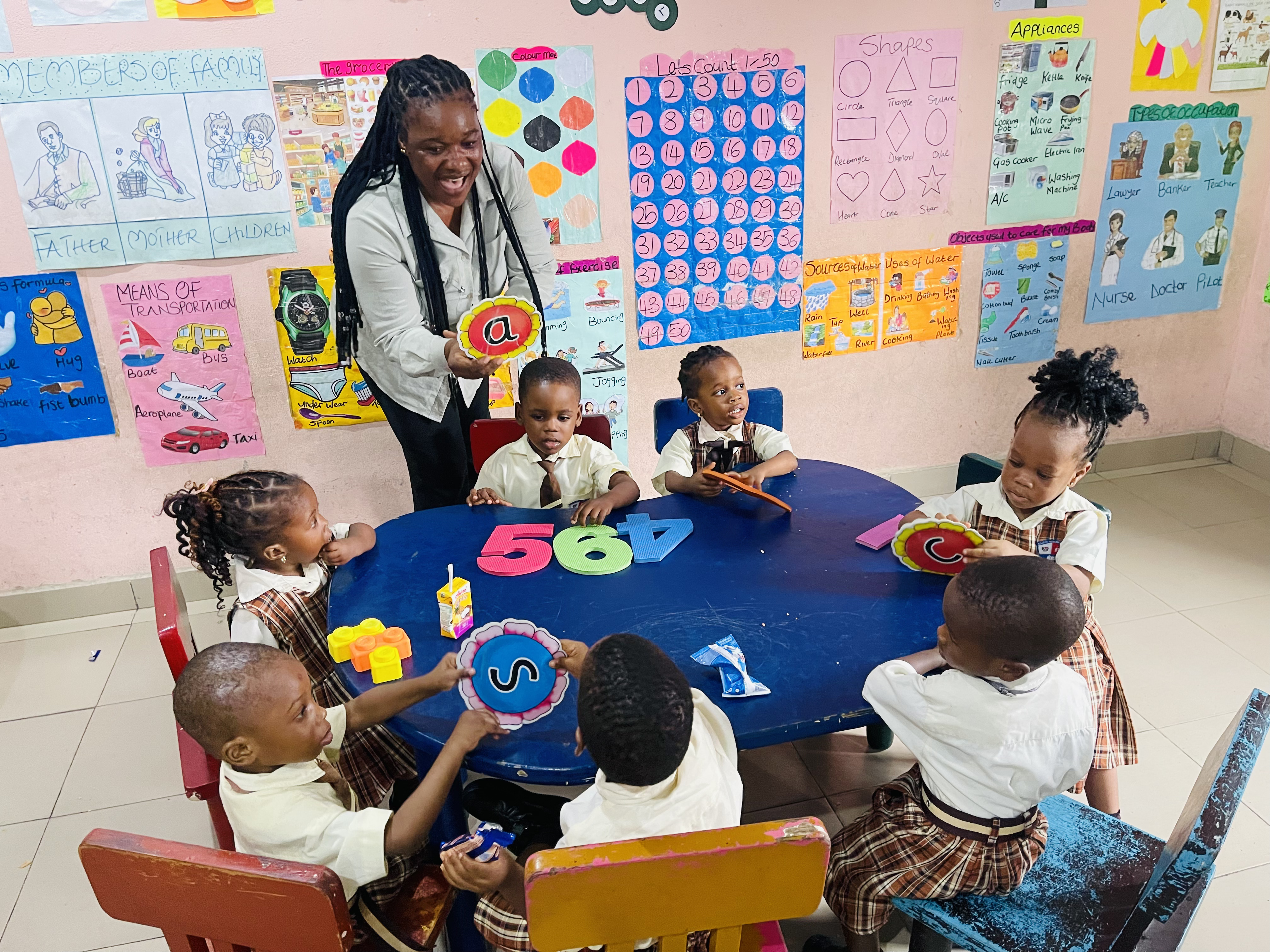 Early-years pupils learning with colourful classroom materials